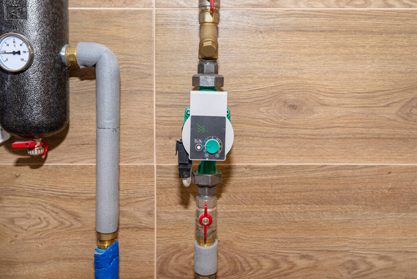 Cirkulační vodní čerpadlo pro podlahové vytápění v moderní plynové kotelně lemované keramickými dlaždicemi. - Fotografie, Obrázek