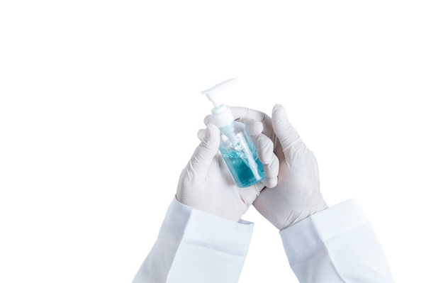 Lékařská ruka má gumové rukavice, drží láhev alkoholu gel izolované na bílém pozadí, zdravotní péče a peotect COVID-19 koncept - Fotografie, Obrázek