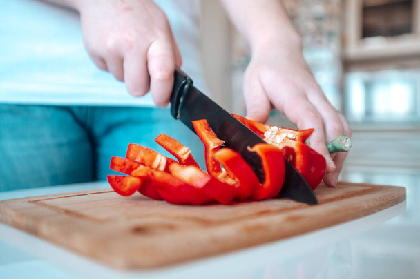 Peper wordt gesneden met een mes - Foto, afbeelding