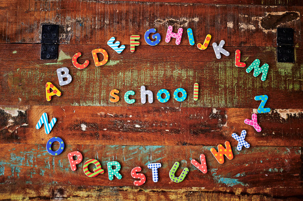Table en bois Auburn avec des lettres colorées qui montrent l'alphabet couché dans un cercle. - Photo, image