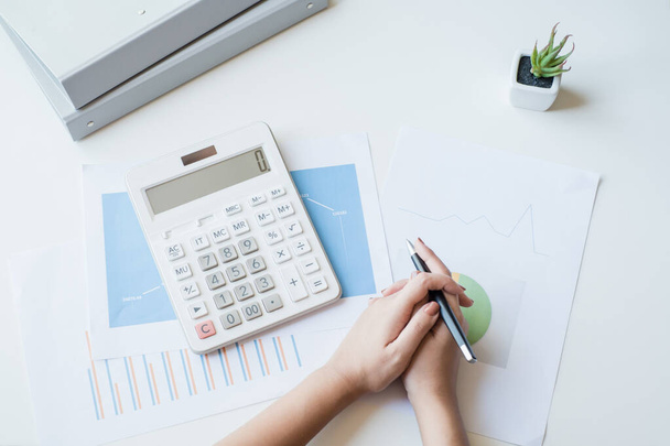 Imprenditrice che utilizza una calcolatrice bianca per calcolare il valore del business finanziario - Foto, immagini