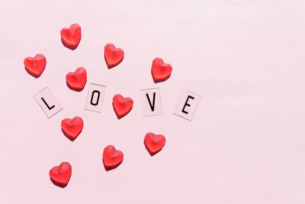 Banner. Das Wort Love.Schwarze Buchstaben Liebe mit roten Herzen. Auf rosa Hintergrund. Valentinstag. Liebevolle, positive Emotionen. Gefühle als Hintergrund. Exklusive Beziehungen. - Foto, Bild