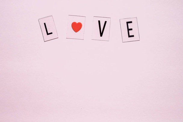 Banner.word Love.Black písmena Láska s červenými srdce.on růžové pozadí.Valentines den. Milující, pozitivní emoce. Pocity na pozadí. Exkluzivní vztahy. - Fotografie, Obrázek