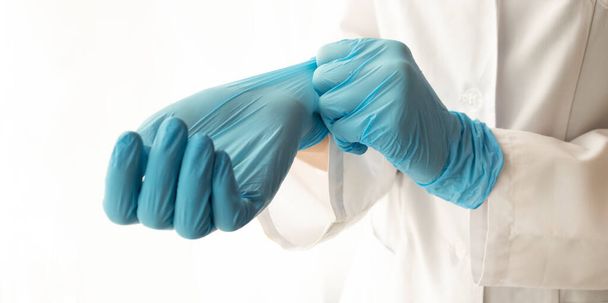 Doctor putting on protective gloves, isolated on white - Foto, Imagem