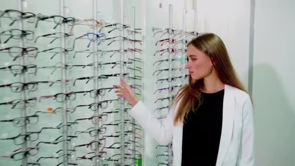 Mujer joven está eligiendo una gafas - Imágenes, Vídeo