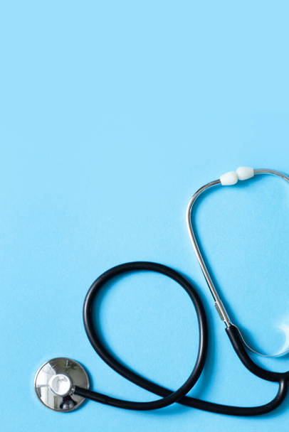 Metal sztetoszkóp orvosi diagnózis kék háttérben. Orvosi és egészségügyi koncepció háttér. Függőleges fénykép - Fotó, kép