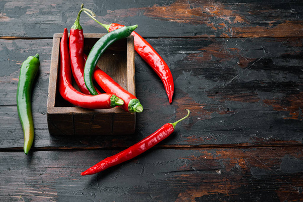 Red and green chili pepper set, in wooden box, on dark wooden background , with copyspace  and space for text - Photo, Image