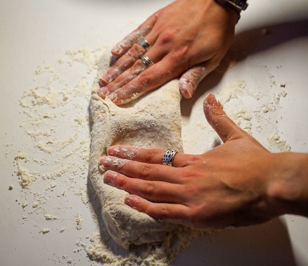 hands of a young woman with a bread dough in a white table - Foto, Imagem