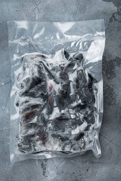 Gefrorene Miesmuscheln vakuumverpackt Set, auf grauem Hintergrund, von oben flach liegend - Foto, Bild