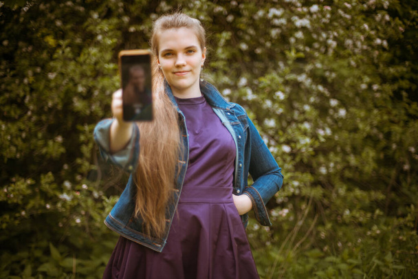 Una ragazza prende un selfie sul suo telefono - Foto, immagini