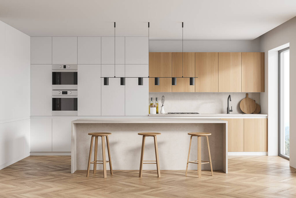 Modern kitchen interior with white walls, a wooden parquet floor and white countertops. A long table with chairs near it. 3d rendering - Foto, afbeelding