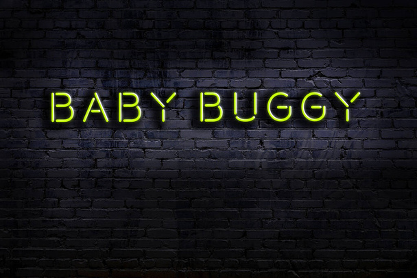 Sinal de néon com inscrição buggy bebê contra parede de tijolo. Vista noturna - Foto, Imagem