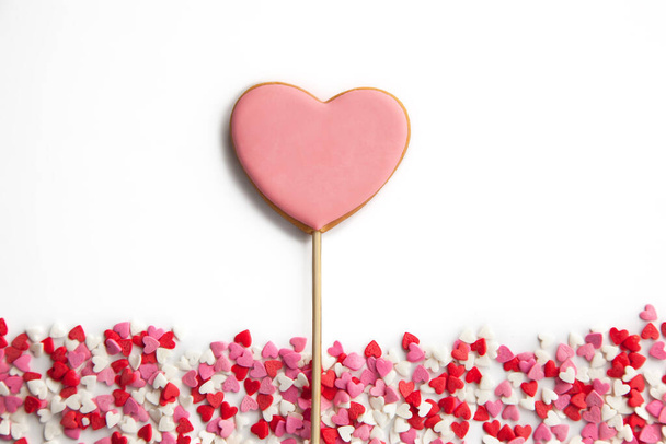 Zoet hart op een stok op een witte achtergrond. Roze koekjes voor Valentijnsdag - Foto, afbeelding