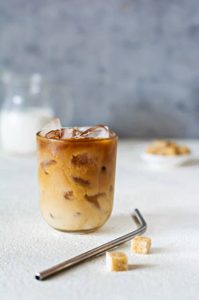 Glass of coffee with ice, milk on a light background. Cold summer drink, Iced coffee. - Fotoğraf, Görsel