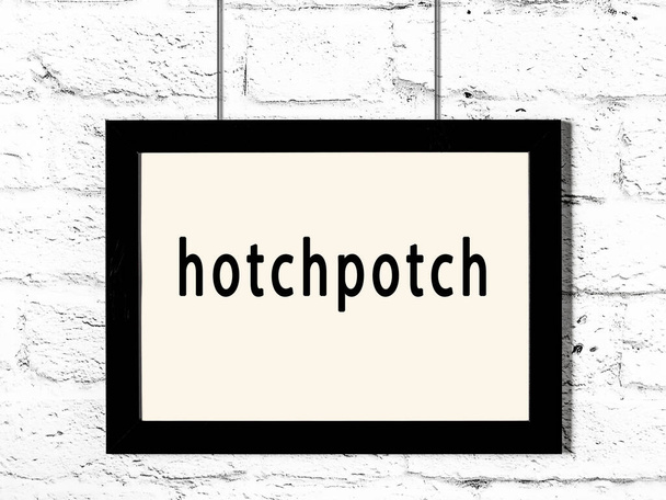 碑文Hotchpotch白いレンガの壁にぶら下がっている黒い木製のフレーム  - 写真・画像