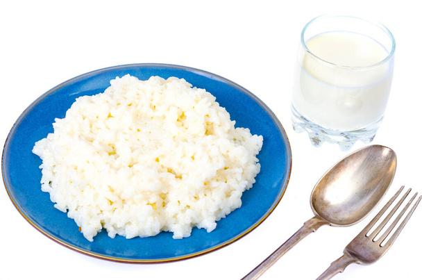 Delizioso porridge di latte di riso in piatto blu su sfondo bianco. Studio Foto - Foto, immagini