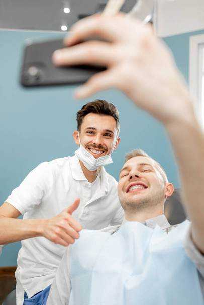 Paciente feliz con un dentista en el consultorio dental - Foto, Imagen