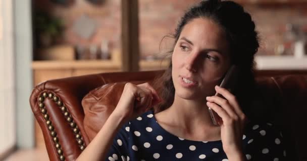 Woman talking on phone while sit on couch at home - Filmagem, Vídeo
