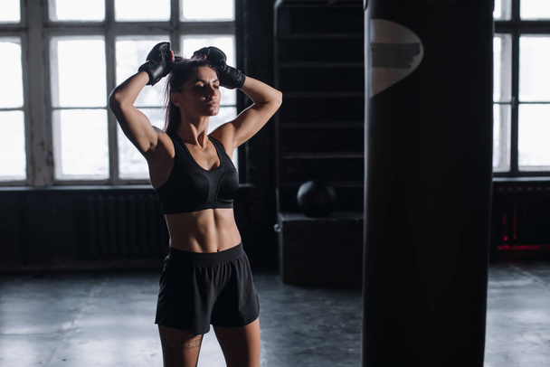 fiatal lány áll egy atmoszférikus fitness terem hátterében szekrények öltözőben - Fotó, kép
