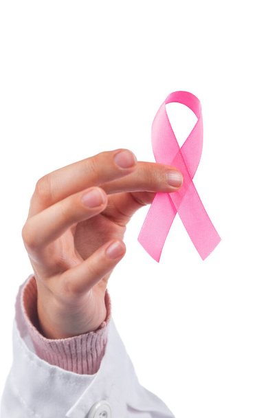 Κοντινό χέρι κρατώντας κορδέλα για τον καρκίνο του μαστού σε λευκό φόντο. - Φωτογραφία, εικόνα