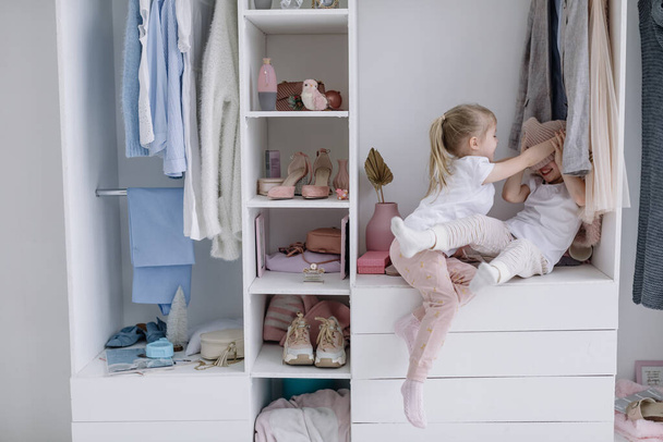 Дівчата Близнюки Спробуйте речі у своїй мами Сучасна роздягальня
.  - Фото, зображення