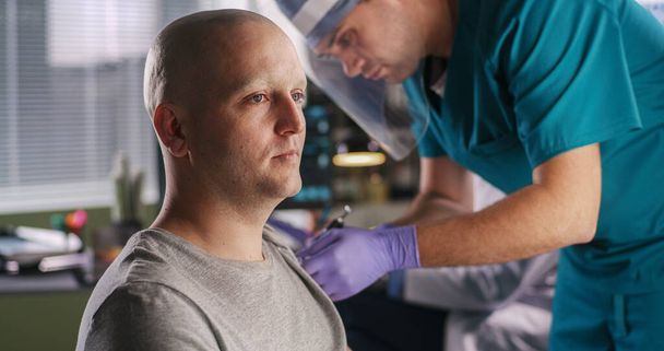 Kale man spreekt met oncoloog tijdens vaccinatie - Foto, afbeelding