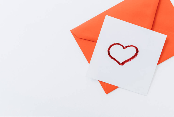 The composition is a red heart and an envelope on a white background.flat lay.copy space. Love, friendship, and a declaration of love.Happy Valentine's Day.Women's Day.Minimal, stylish holiday concept - Foto, Imagen