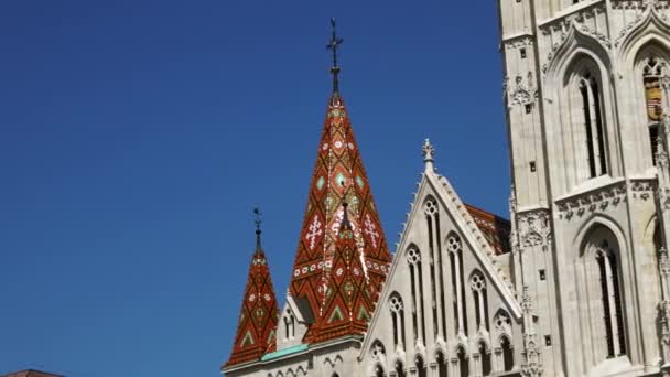 De kleurrijke tegels van een van de torens op het dak van de Matthias kerk, Fisherman 's Bastion, Boedapest, Hongarije op een heldere zonnige dag met een heldere blauwe lucht op de achtergrond. - Video