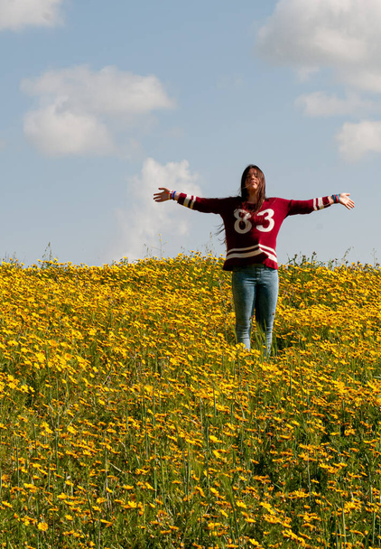 Chica feliz y un campo con flores amarillas en primavera - Foto, Imagen