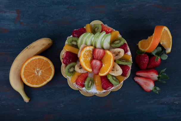 Fruit Cake with strawberries, raspberries and blueberries. Fruitcake with oranges, bananas and apples. Gift cake, birthday cake. - Φωτογραφία, εικόνα
