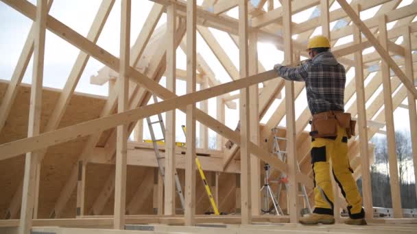 A ház új faépítészeti kerete. Építőipari munkás és munkája a csontváz keret. - Felvétel, videó