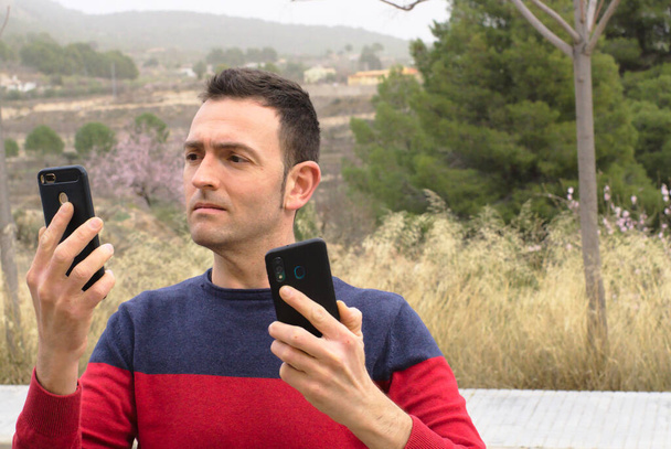 Znepokojený mladý muž používající obrazovku s chytrým telefonem. Koncept: závislost na sociálních médiích. - Fotografie, Obrázek