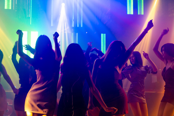 Σιλουέτα εικόνα των ανθρώπων χορεύουν στο νυχτερινό κλαμπ ντίσκο με μουσική από DJ στη σκηνή - Φωτογραφία, εικόνα