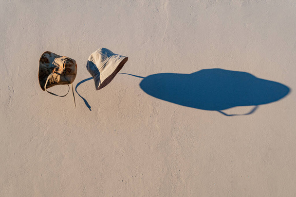 καπέλα κουβά που πετούν στον αέρα, σε ένα φόντο γκρι τσιμέντο - Φωτογραφία, εικόνα