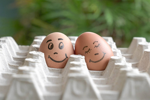 Faces painted on two eggs. Concept for love romance, valentine's day. - 写真・画像