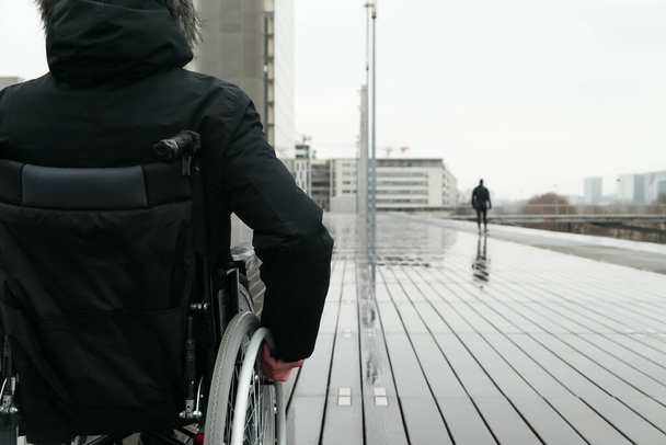 Έννοια των ατόμων με αναπηρία. Άντρας σε αναπηρικό καροτσάκι έξω στο δρόμο.. - Φωτογραφία, εικόνα