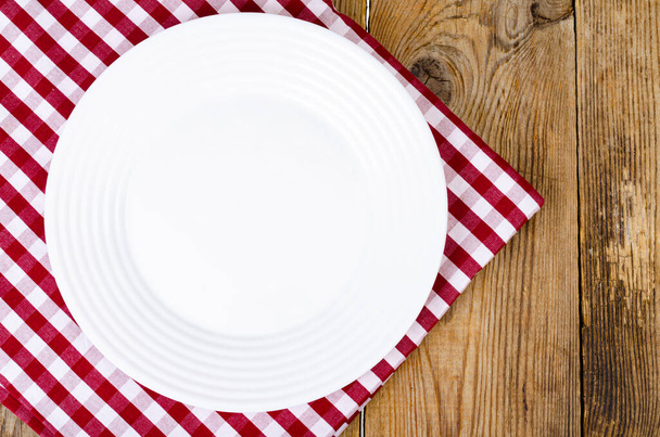 Концепция Рождества и Нового года. Белая тарелка, красная скатерть. - Фото, изображение
