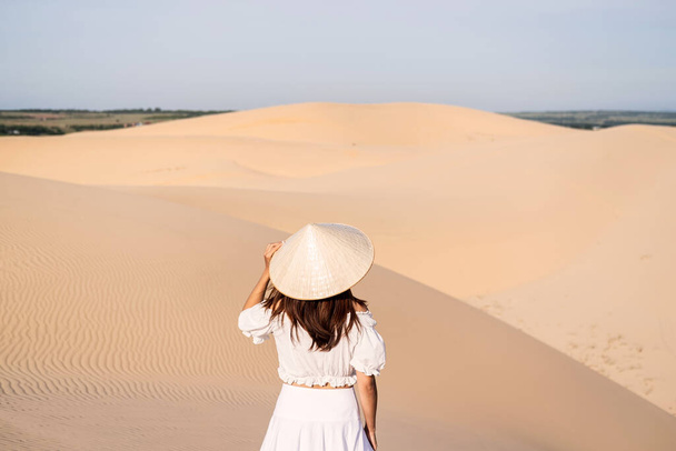 Νεαρή γυναίκα ταξιδιώτη απολαμβάνοντας σε λευκή άμμο αμμόλοφους στο Βιετνάμ, Ταξιδιωτικός τρόπος ζωής έννοια - Φωτογραφία, εικόνα