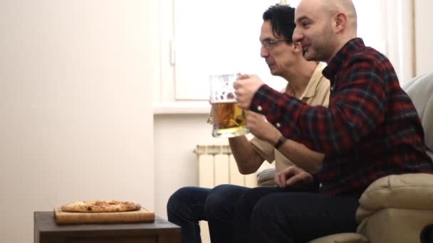 mężczyzn, oglądanie piłki nożnej i piwa do picia - Materiał filmowy, wideo