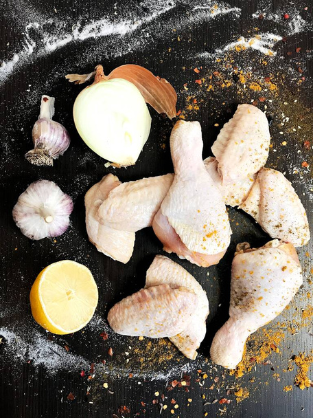 syrová kuřecí křidélka zdobená kořením na tmavém stole - Fotografie, Obrázek