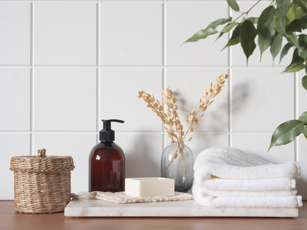 Λευκό μπάνιο με φόντο μπροστινή όψη με καλλυντικά μπουκάλι, αξεσουάρ μπάνιου στο ράφι από ξύλο και πλακάκια τοίχου. Αντιγραφή χώρου - Φωτογραφία, εικόνα