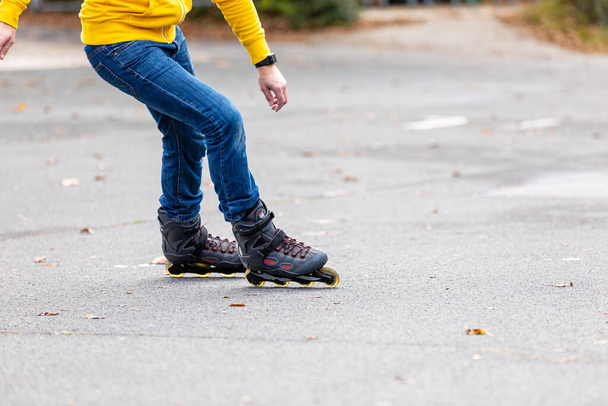 A closeup view of a person is wearing rollerskates and having fun in the park outside - Valokuva, kuva