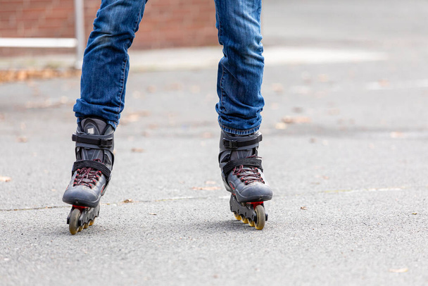 A closeup view of a person is wearing rollerskates and having fun in the park outside - Fotografie, Obrázek