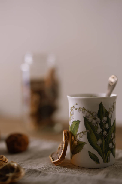 A vertical selective focus of dried lemon tea in a white mug on a fabric surface - Zdjęcie, obraz