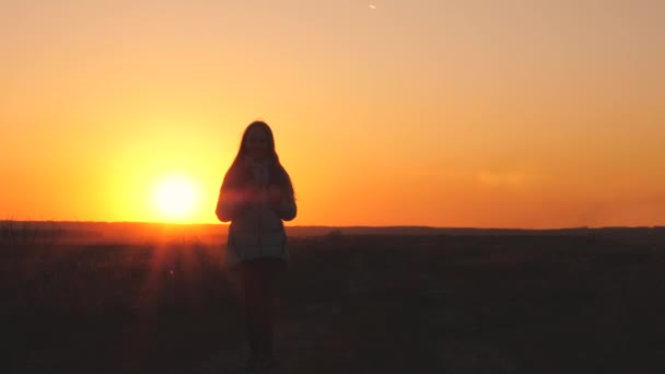 Egy lány utazó hátizsákkal a hátán sétál és mosolyog a naplementében az égen. Egy tinédzser kempingezni ment nyaralni. Gyerekkor, kalandot keresve reggeltől hajnalig. Szerelem a - Felvétel, videó