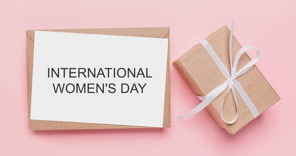 Geschenke mit Zettel auf isoliertem rosa Hintergrund, Liebe und Valentinskonzept mit Text Internationaler Frauentag - Foto, Bild