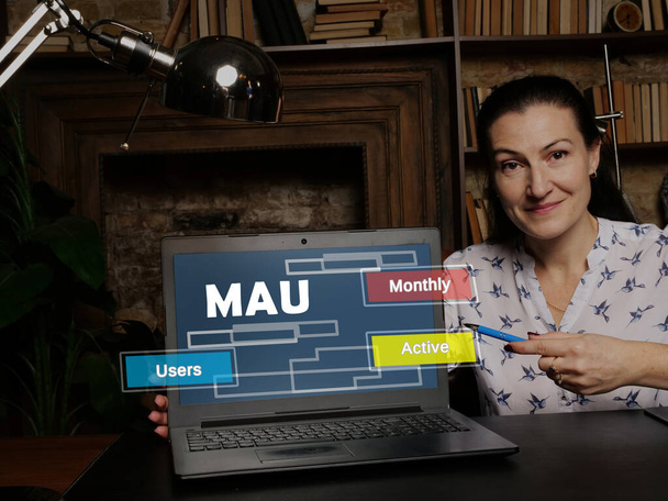 Geschäftsfrau bei der Arbeit mit Finanzberichten MAU Monthly Active Users und einem Lapto - Foto, Bild