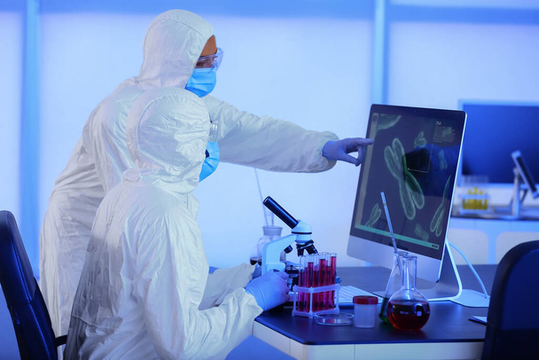 Scientists studying sample in laboratory - Foto, Bild