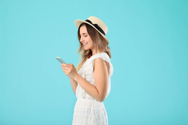 Young woman with mobile phone on color background - Foto, Imagem