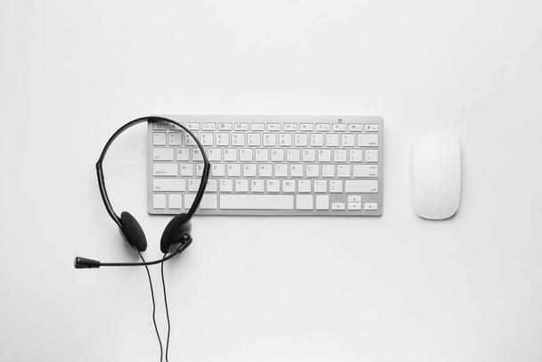 Headset with computer keyboard on white background - Φωτογραφία, εικόνα